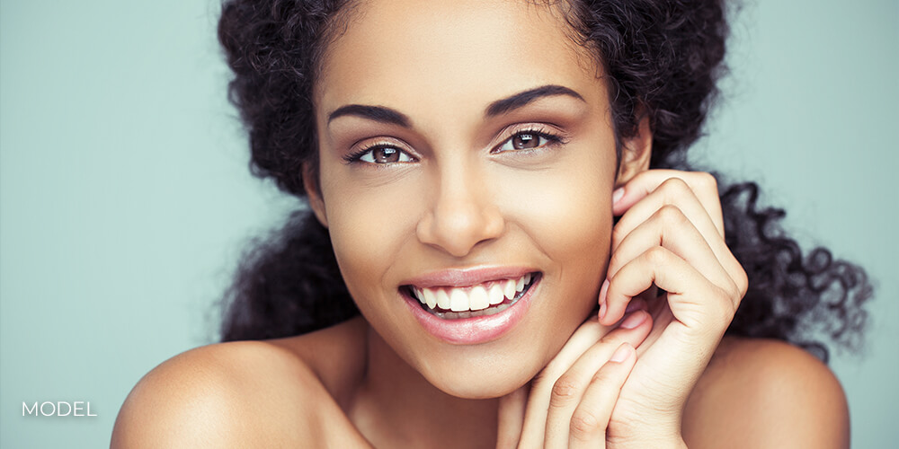 Forehead & Eyebrow Lift By Dr. Mariam Awada Portrait of a beautiful young African woman smiling.