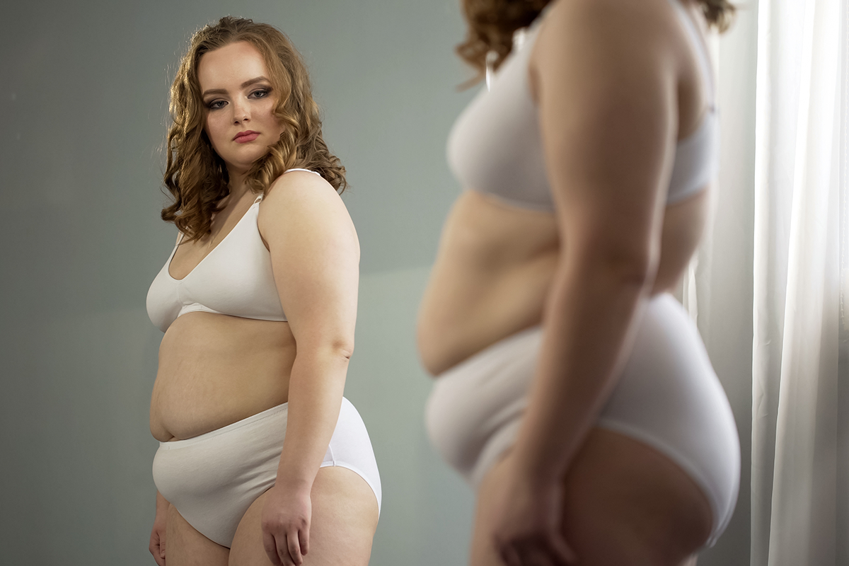 fat lady attentively looking at her mirror reflection fat lady attentively looking at her mirror reflection